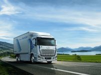White,truck,driving,on,the,asphalt,road,next,to,the