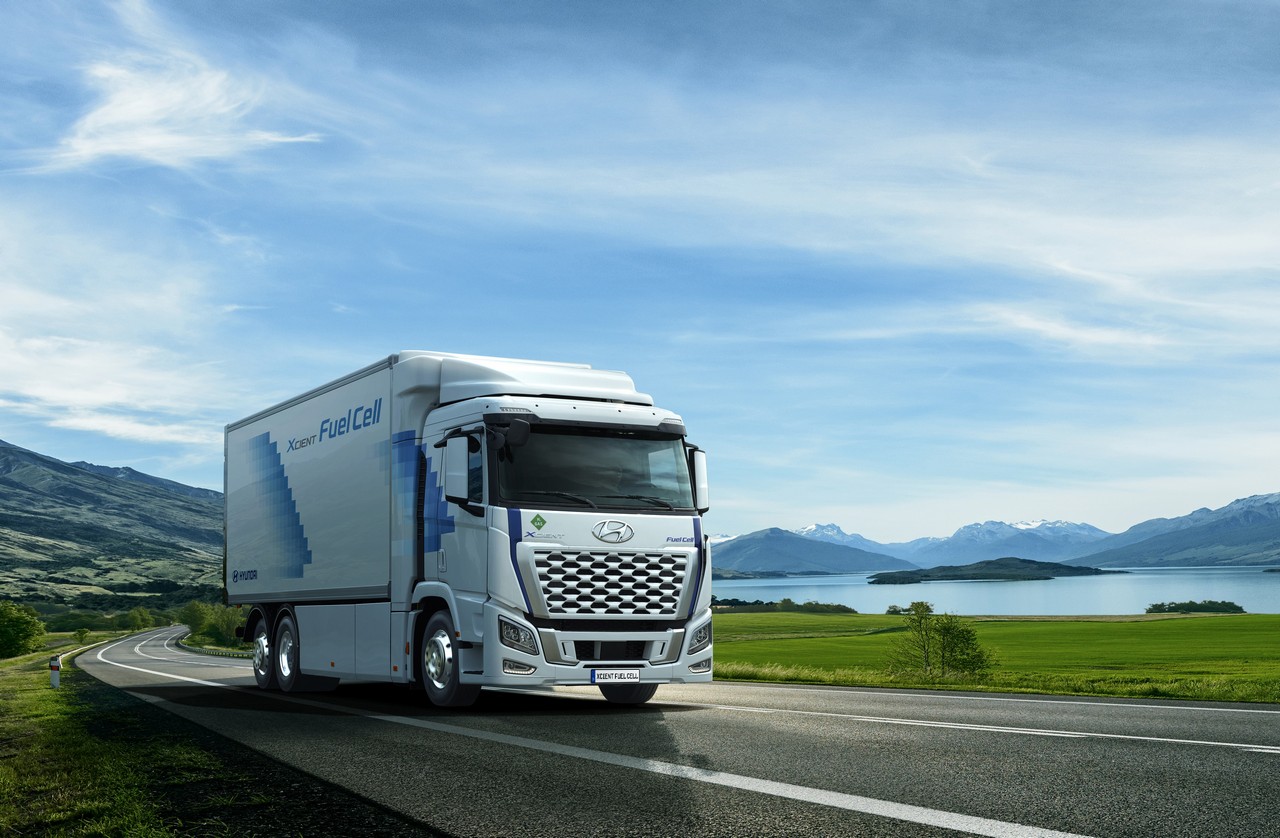 White,truck,driving,on,the,asphalt,road,next,to,the
